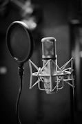 grayscale photo of condenser microphone beside pop filter