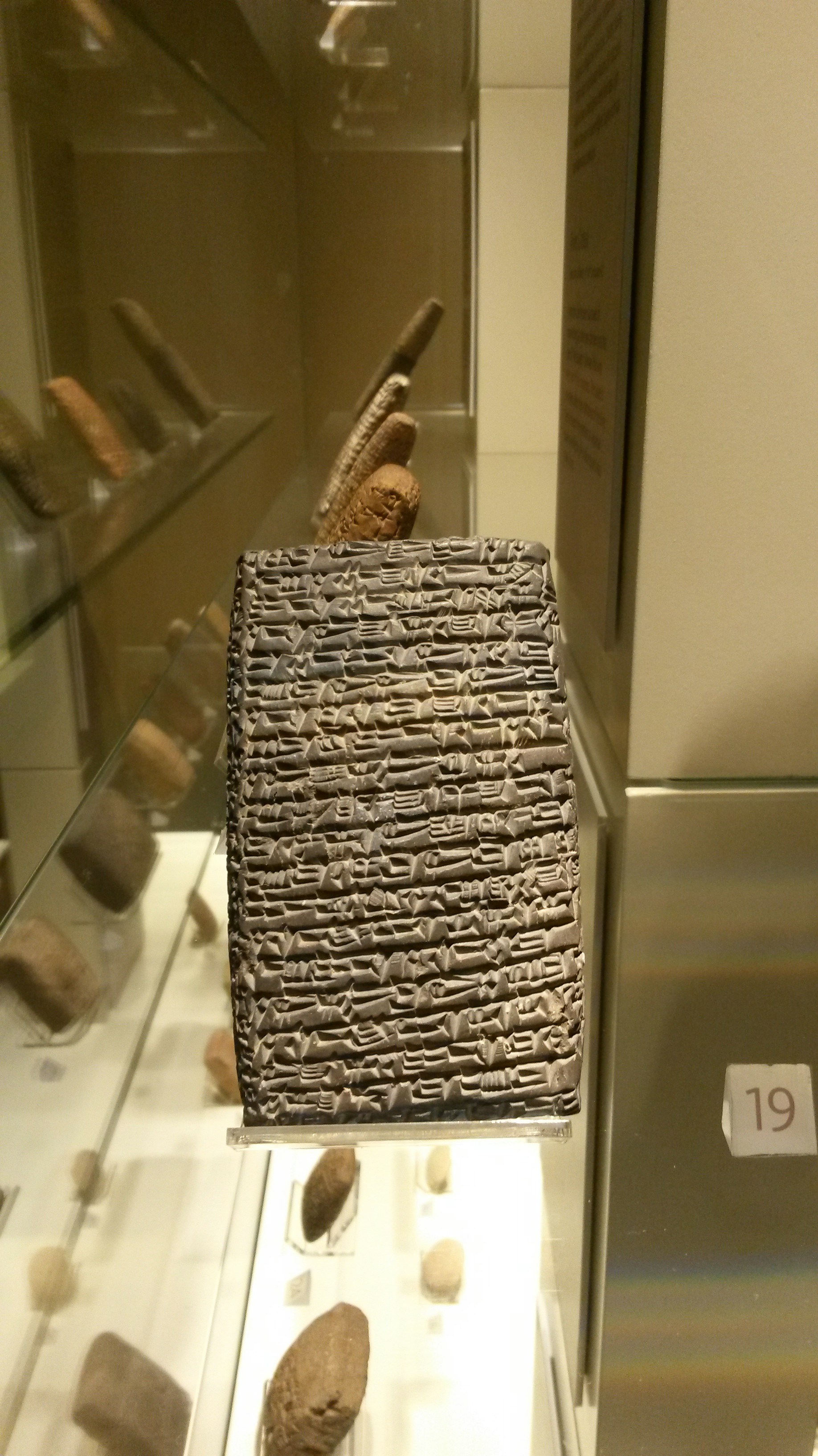 Ancient clay tablets with cuneiform script inscriptions in warm museum lighting