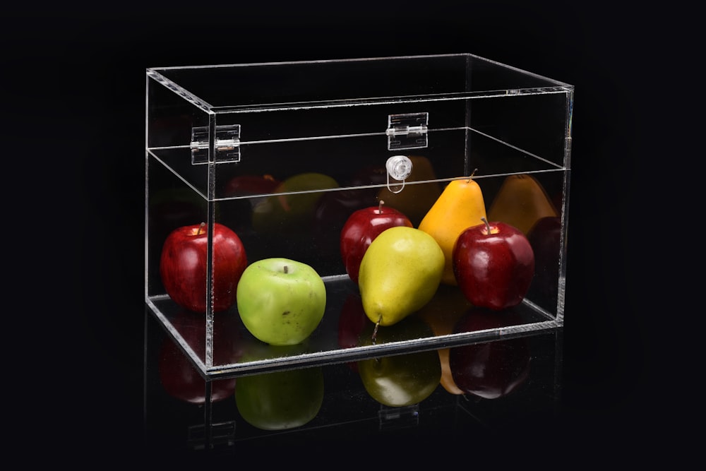 manzana y pera en vitrina de cristal transparente