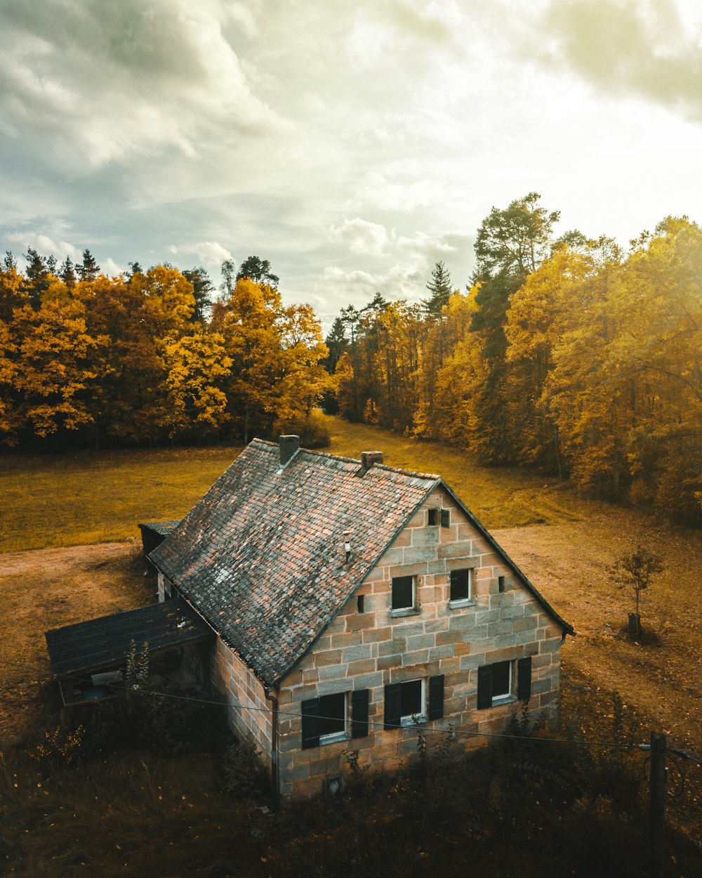 brown and gray concrete house near trees during cloudy day