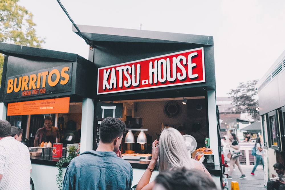 a group of people standing outside of a restaurant