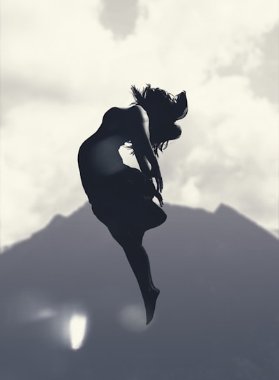 silhouette of person jumping in mid-air during daytime