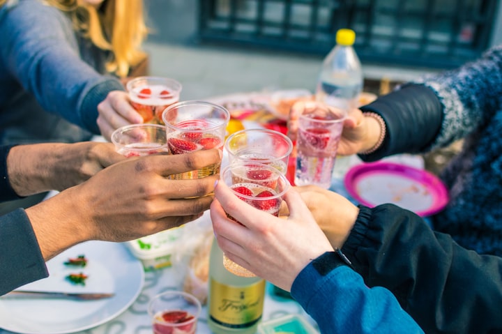 Group cheersing drinks outside at summer party