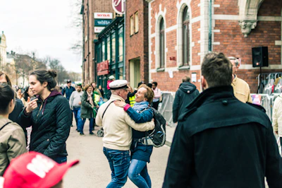 A lively street scene with diverse people smiling and engaging in friendly conversation during a community event.