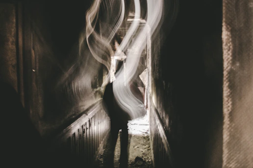A pixelated eerie hallway from a PS1-style horror game, dimly lit with flickering lights.