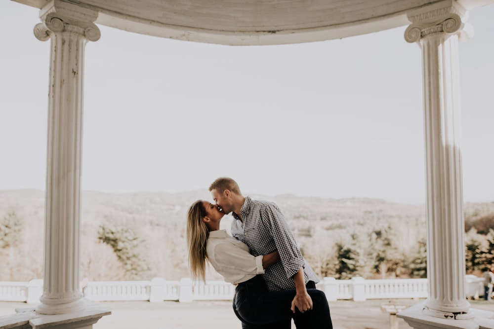 man and woman kissing under gazebo