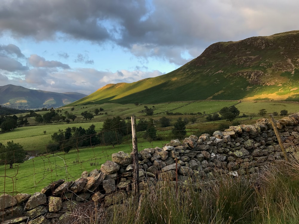 piled stone fence and green mountain