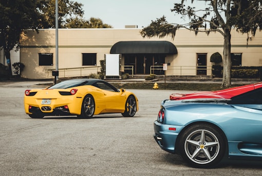 three Lamborghini coupes near building at daytime