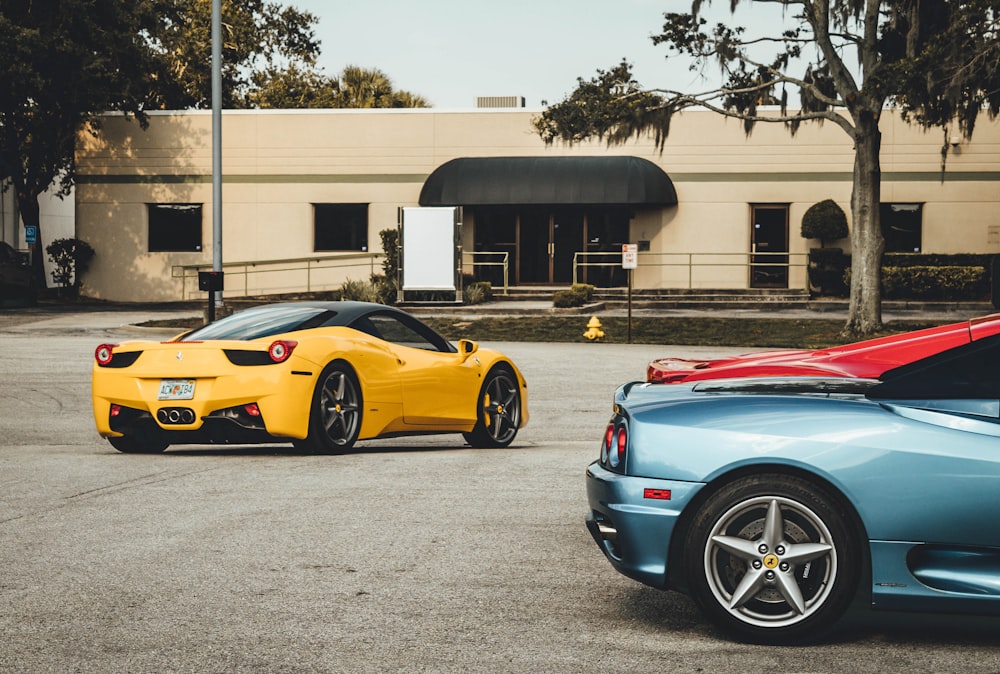 three Lamborghini coupes near building at daytime