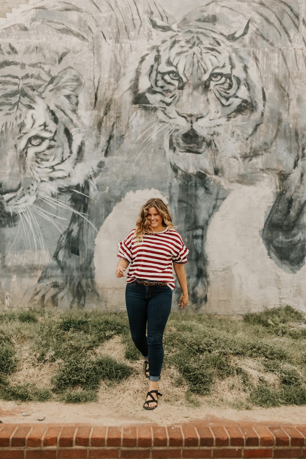 mulher em pé ao lado da parede impressa do tigre
