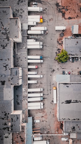 A fleet of trucks parked outside a warehouse, ready for local cargo transport.