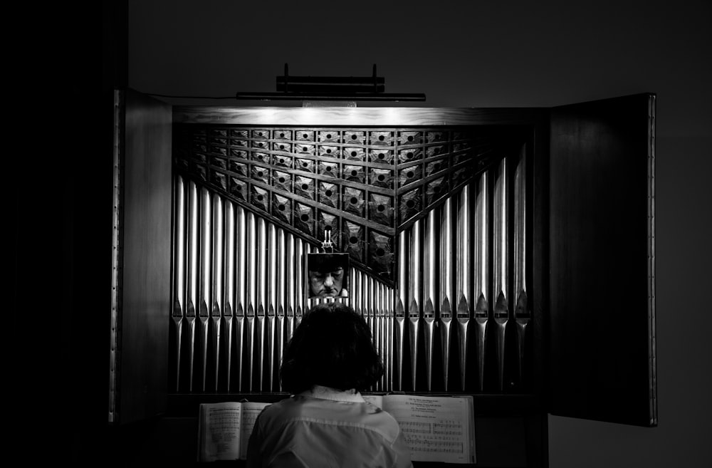 grayscale photo of woman stand in front of mirror