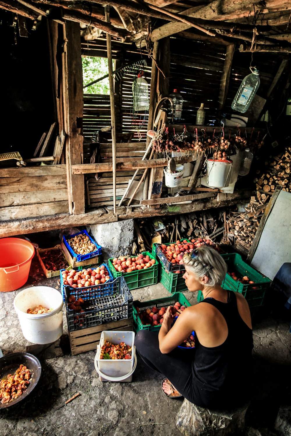 woman sitting on stool arranging fruits