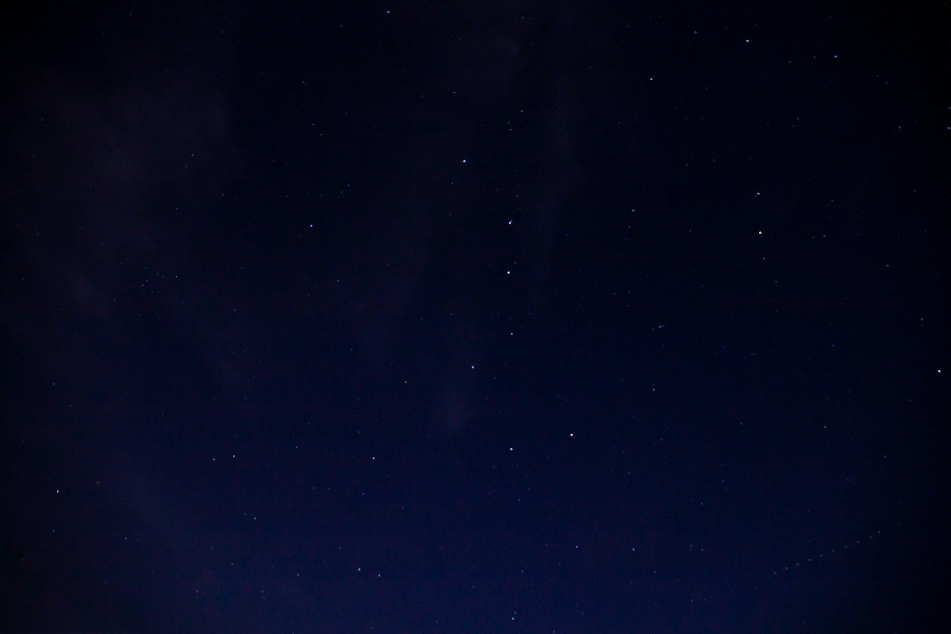 a night sky with stars and a few clouds