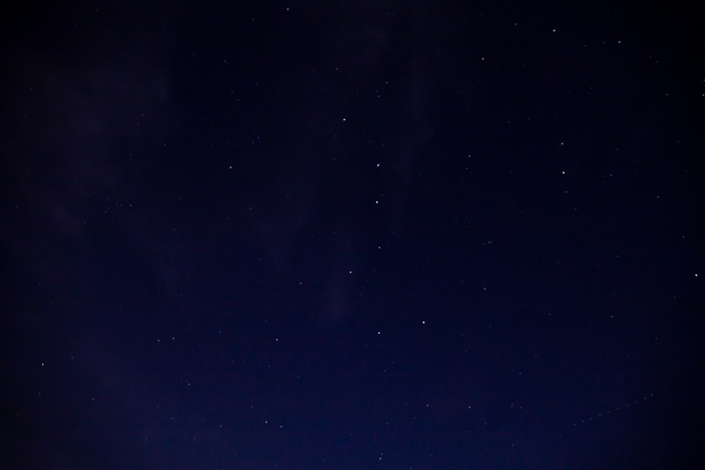 a night sky with stars and a few clouds