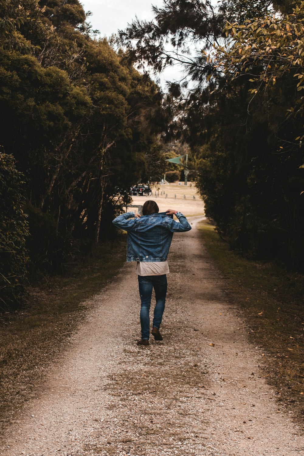 person holding denim jacket while walking