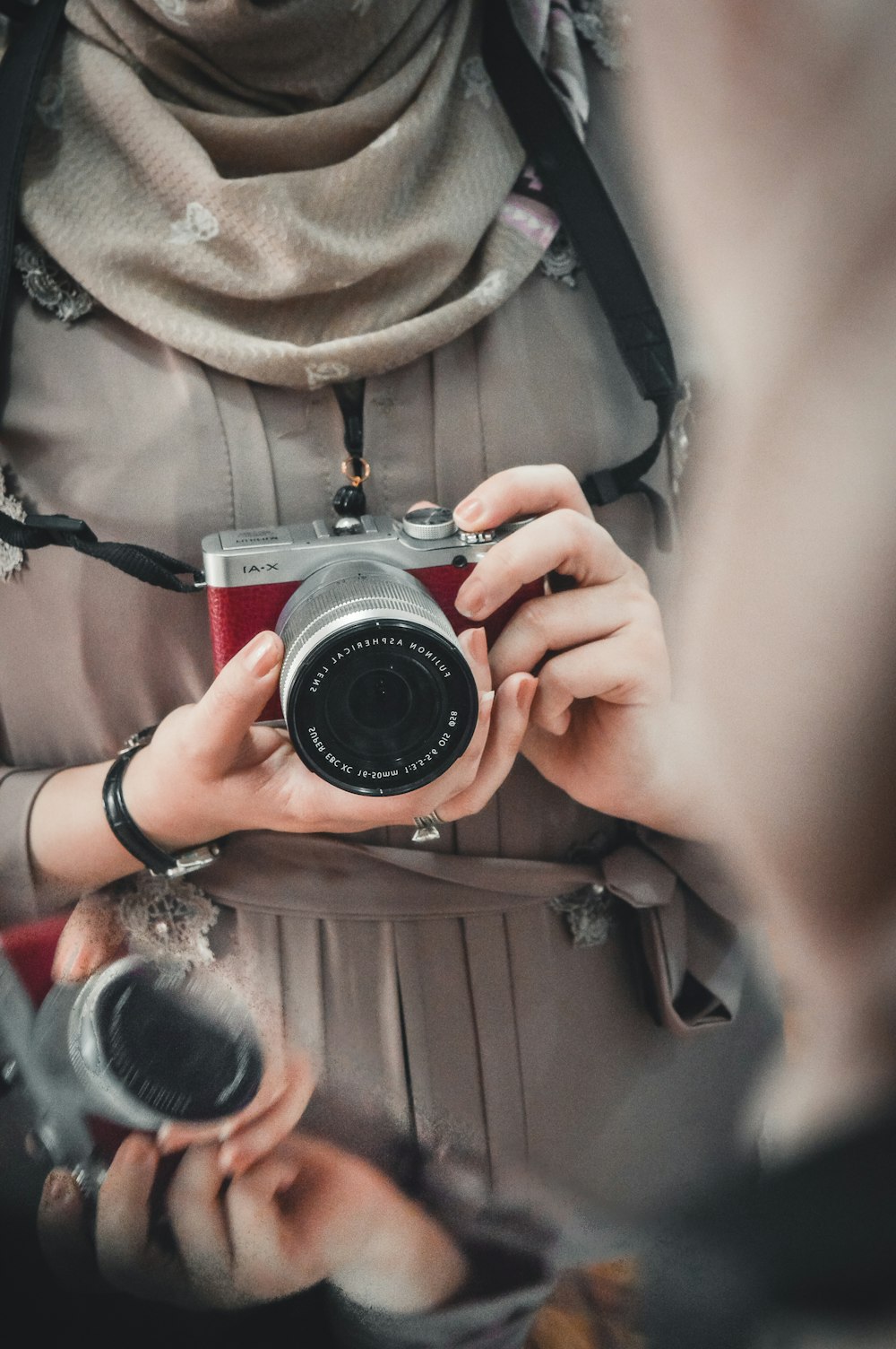 person holding red and silver SLR camera