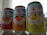 Three cans of Sanpellegrino sparkling beverages are placed side by side, each labeled with different fruit flavors: blood orange, orange, and grapefruit. The design features bright, colorful images of the corresponding fruits with a star logo above the brand name. The cans have details about the juice content and other natural flavors.