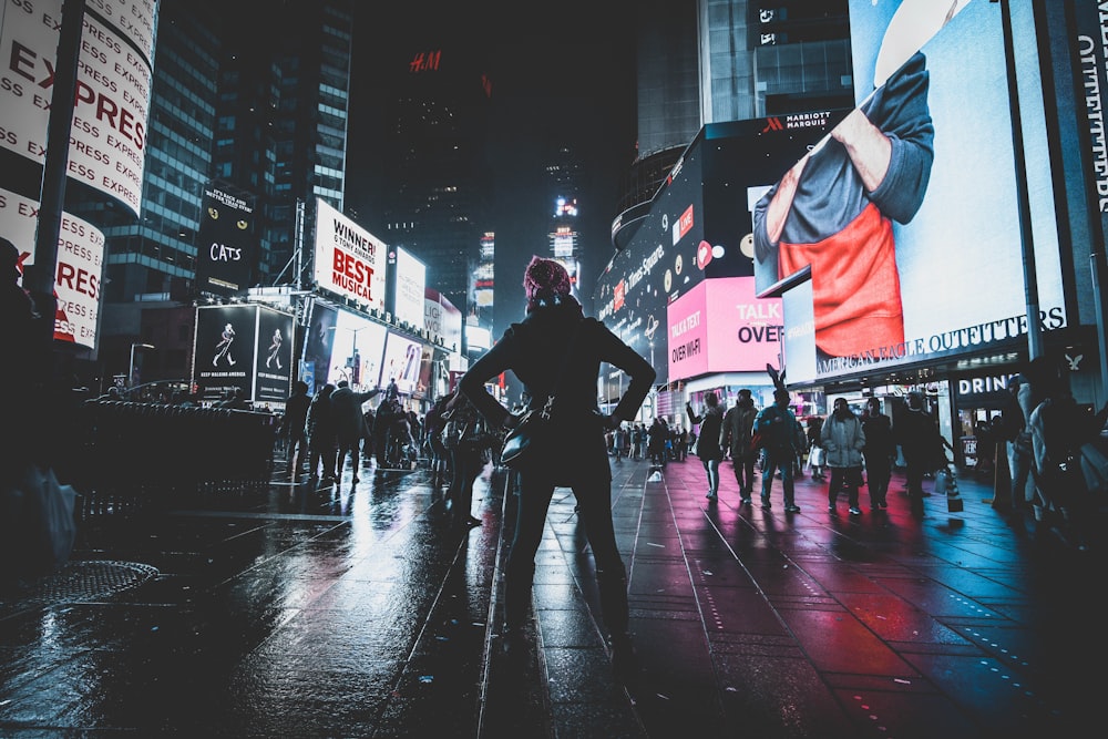 woman standing in between high-rise buildings