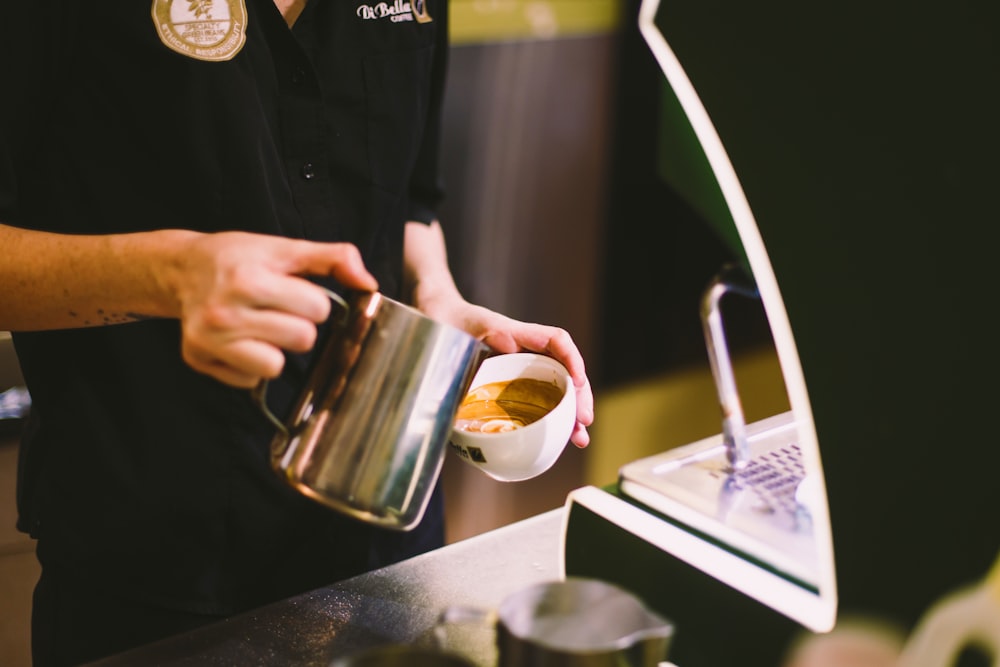 person pouring coffee on mug