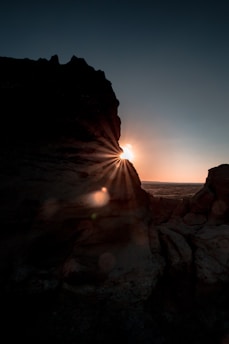 silhouette of mountain near body of water during golden hour