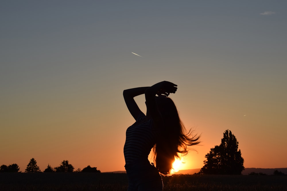 silhouette of person raising both hands