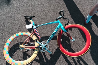 blue and red specialized fixie bike on grey surface wheel zoom background