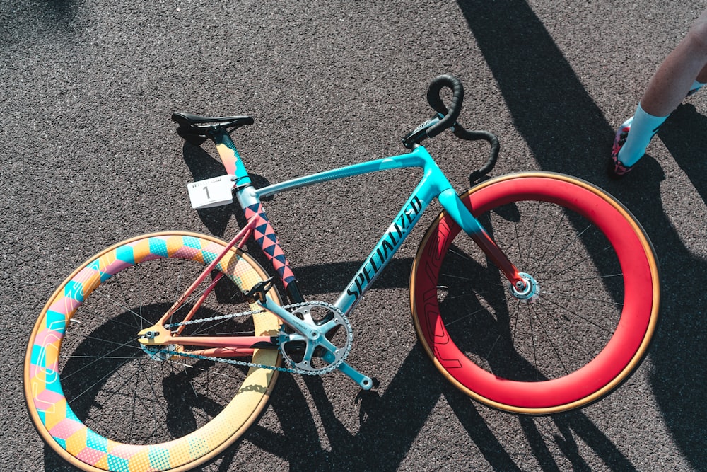 Bicicleta fixie Specialized azul y roja sobre superficie gris