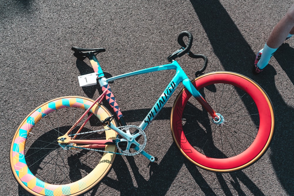 blaues und rotes Specialized Fixie Bike auf grauem Untergrund