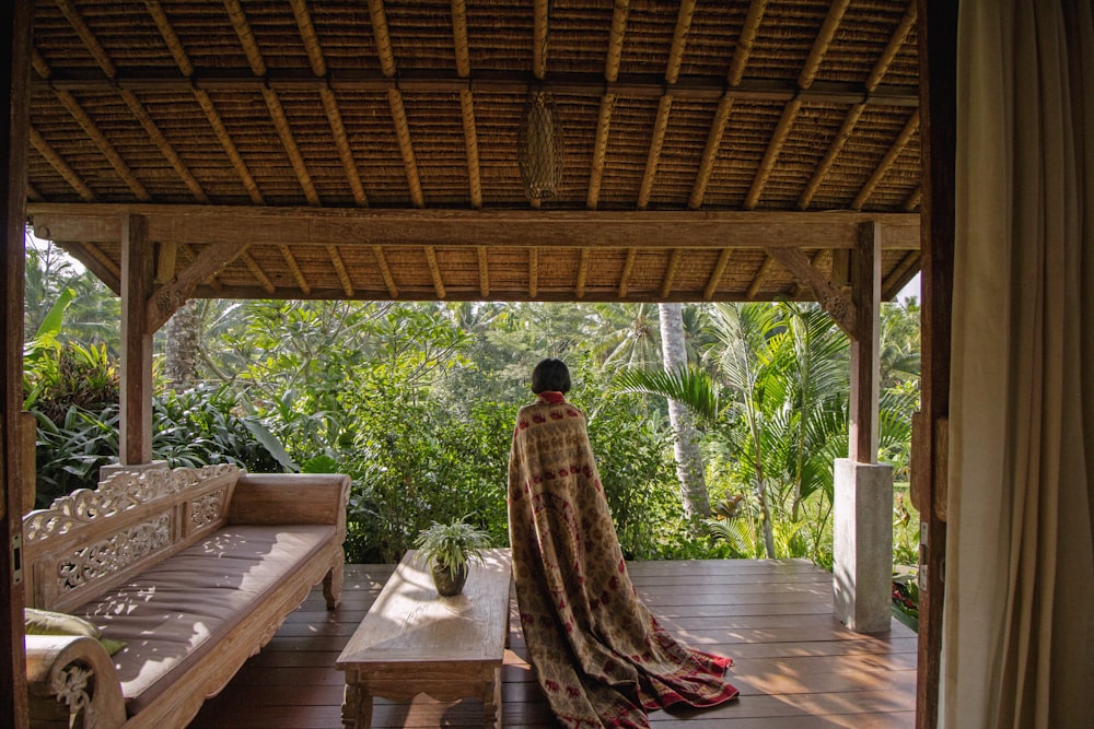 person standing while covered with textile near sofa