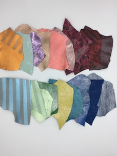 Close-up of elegant fabric swatches in soft pastel orange and olive green tones arranged neatly.