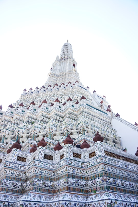 white, blue, and red floral tower building in Wat Arun Ratchawararam Ratchawaramahawihan Thailand