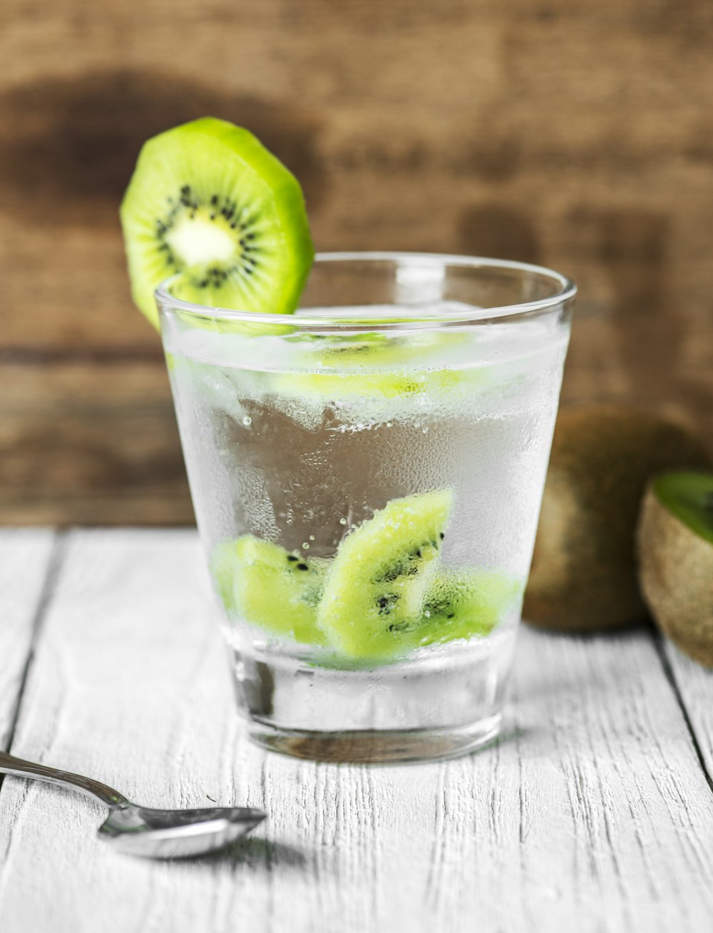 water in glass with sliced kiwi