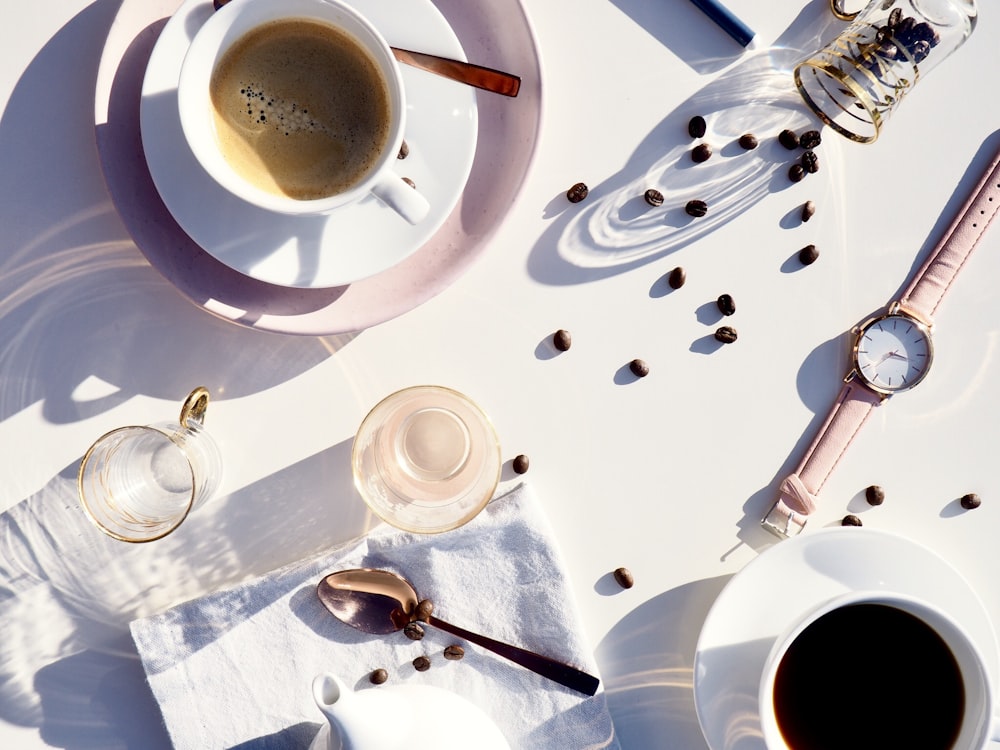 Fotografía plana de taza de té, platillo, reloj, taza y cuchara