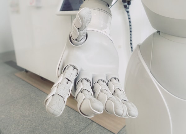 a light-colored robotic hand reaching toward the viewer