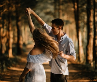 man and woman dancing at center of trees