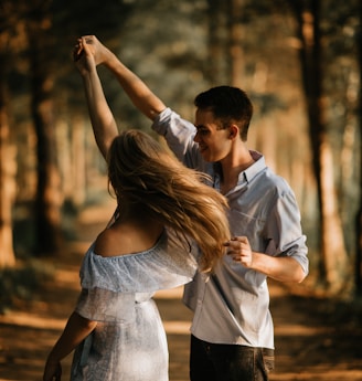 man and woman dancing at center of trees