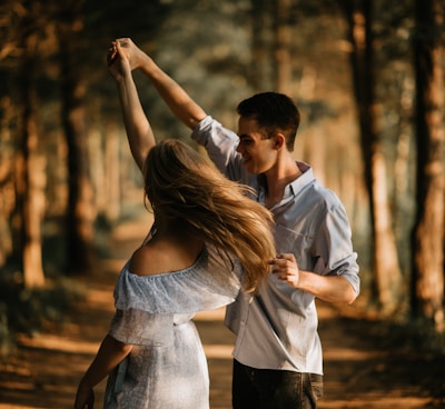 man and woman dancing at center of trees