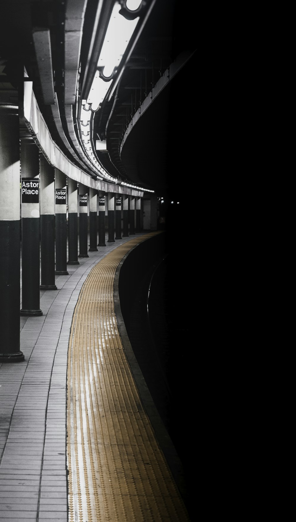 Foto in scala di grigi della rotaia del treno sul tunnel