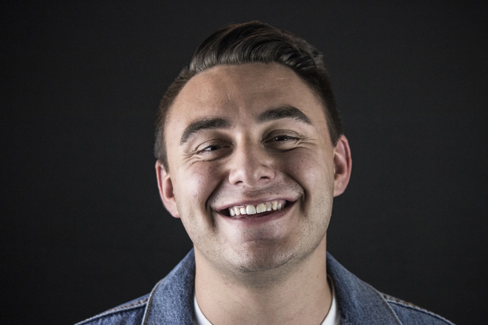 smiling man wearing blue denim jacket