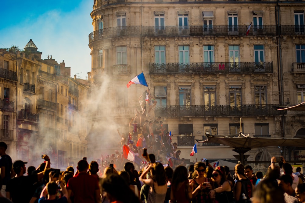 建物の近くでフランス国旗を振る人々