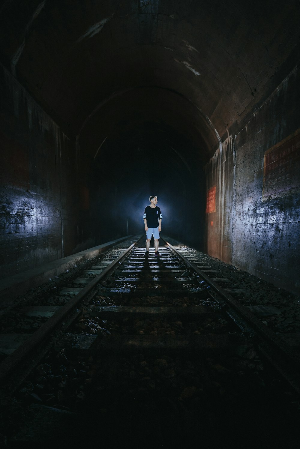 man standing on train tunnel