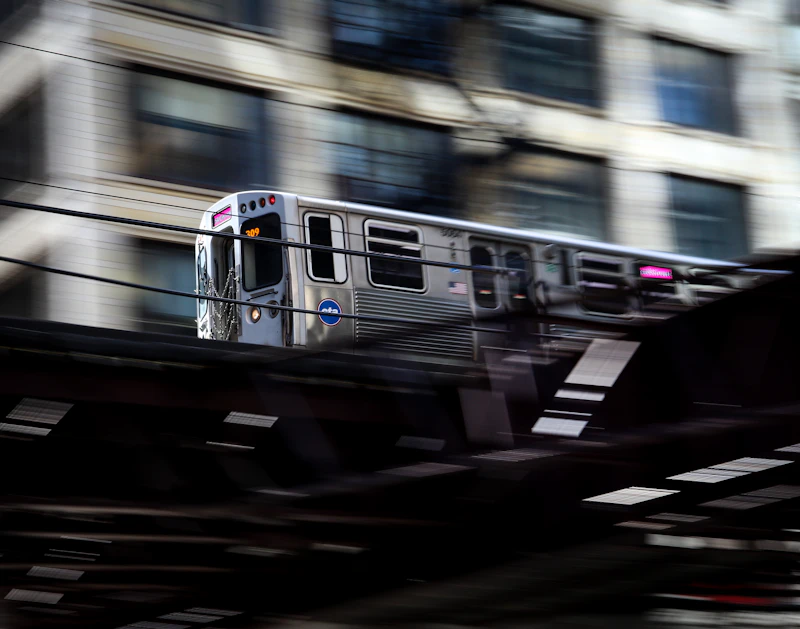 A CTA 'L' train in motion on elevated tracks in downtown Chicago