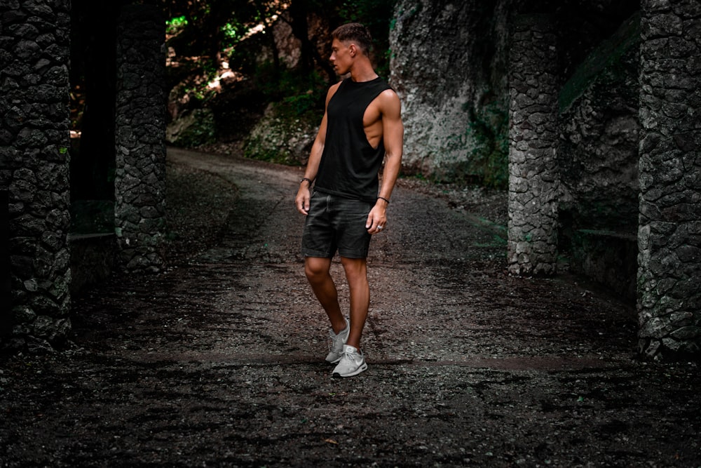 man standing on pathway between concrete post