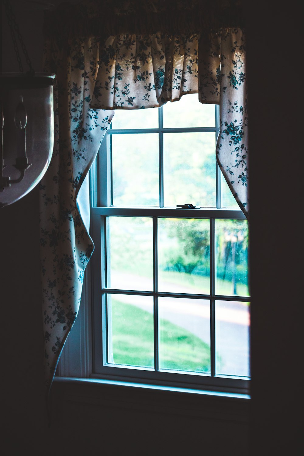 glass sash window with white floral curtain