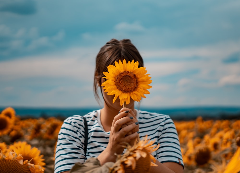 woman holding yellow sunflower