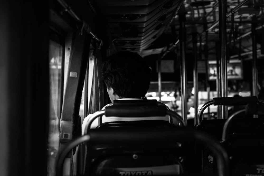 grayscale photography of of person sitting on car interior