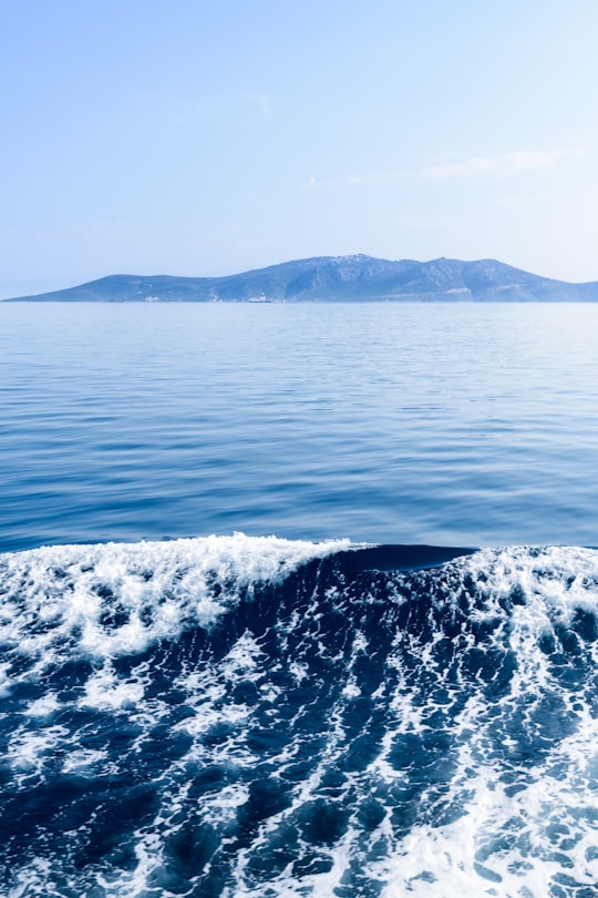 sea waves and mountain range during daytime in landscape photography in Koukounaries Greece