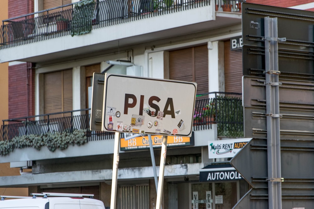 건물 근처의 흰색 PISA 도로 표지판