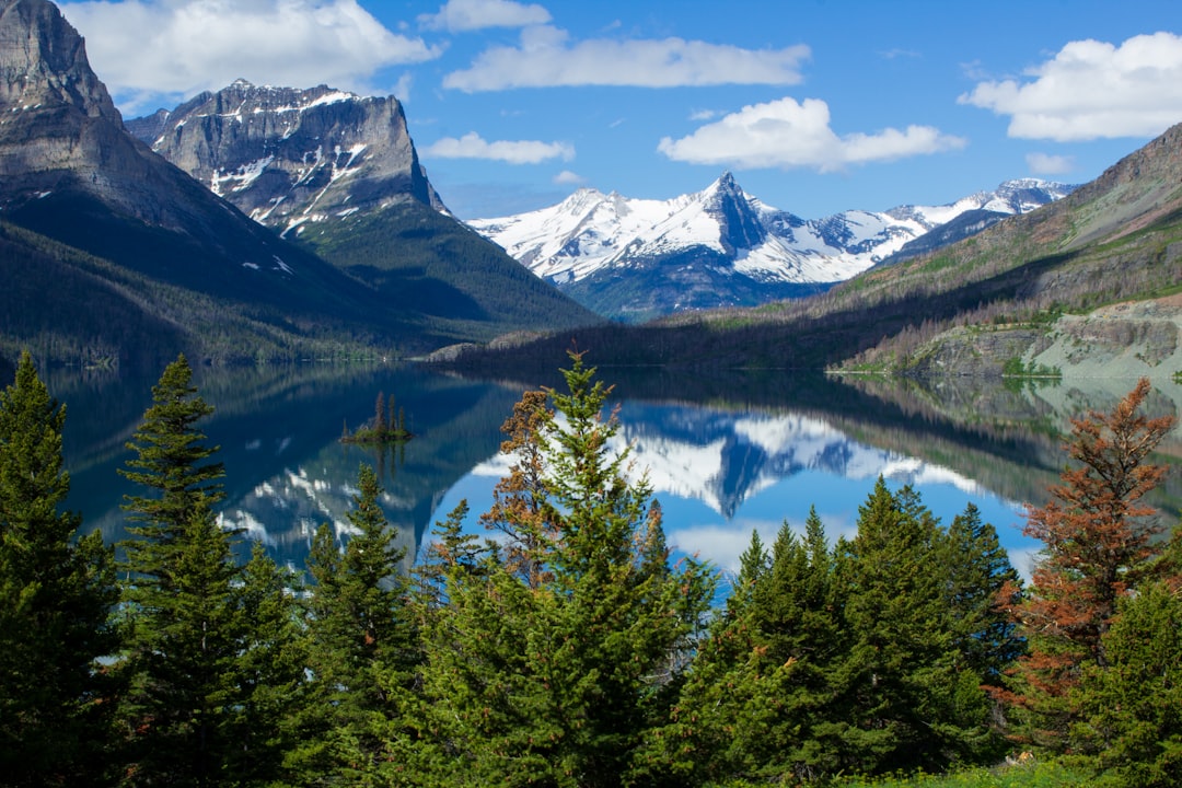 lake surrounded by mountains at daytime,